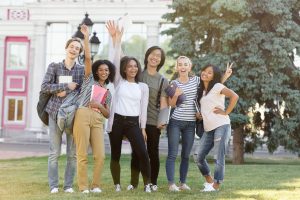 Image of multiethnic group of young cheerful students going for their medical coding training at MIIT Global Services